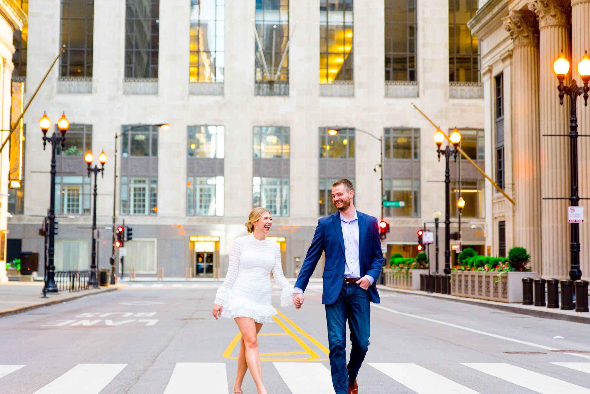 man and woman holding hands laughing in front of Chicago Board of Trade