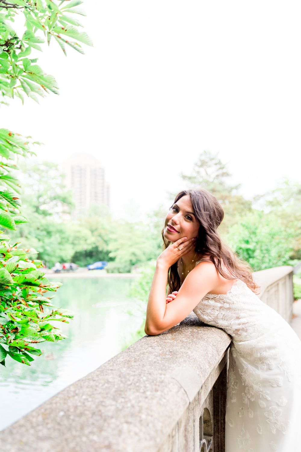bride leans over bridge at Eden Park showing off her ring