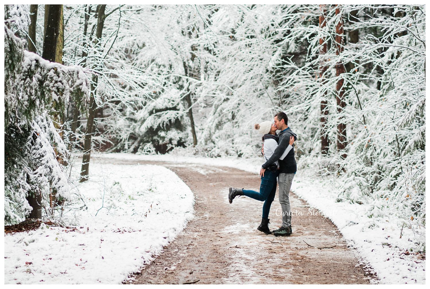 Couple kissing in the snow in Austria in the woods in winter