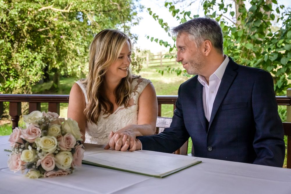 Bride and groom signing register after Lake District wedding