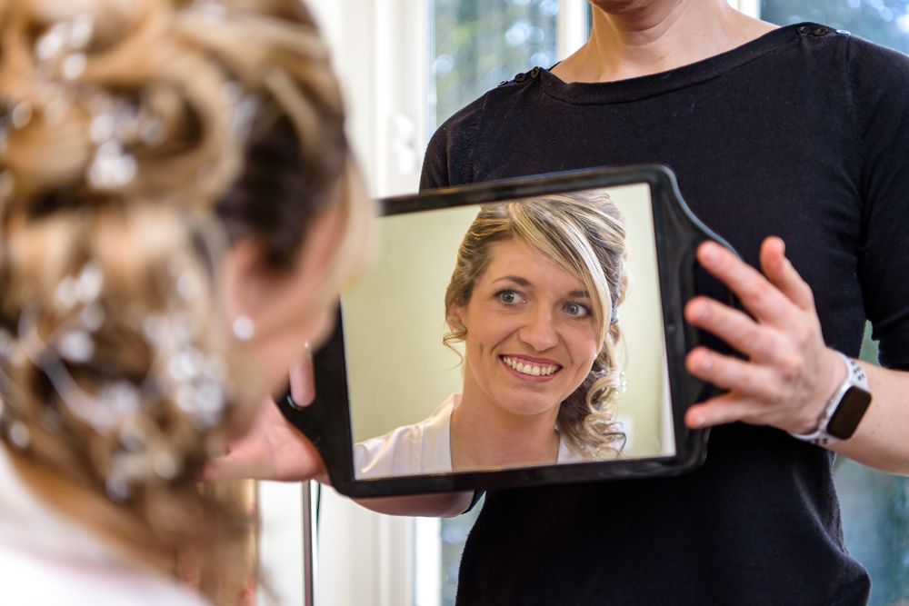 Bride checks her makeup in mirror before Lake District wedding