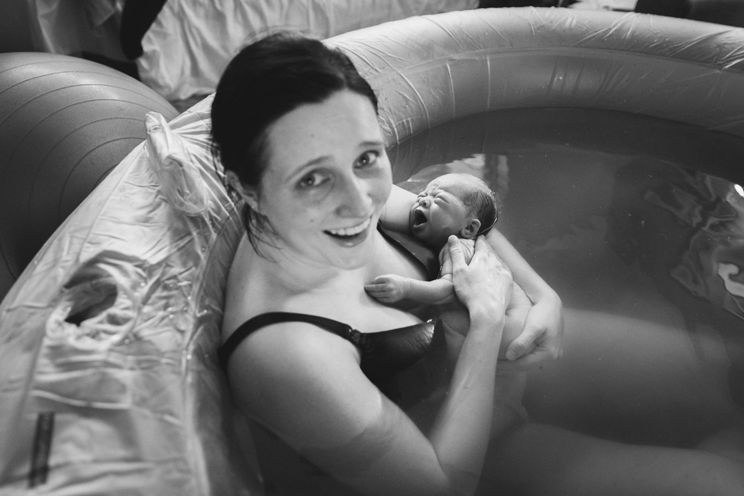 woman giving birth in pool at home