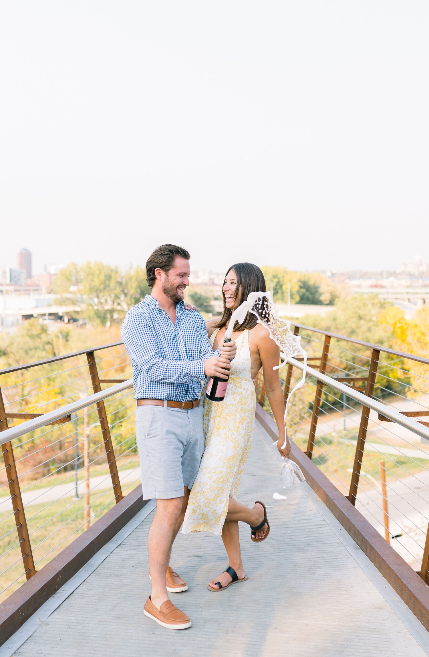 Des Moines Engagement photos with skyline of downtown Des Moines, Iowa with light and airy photographer Nicole Laing