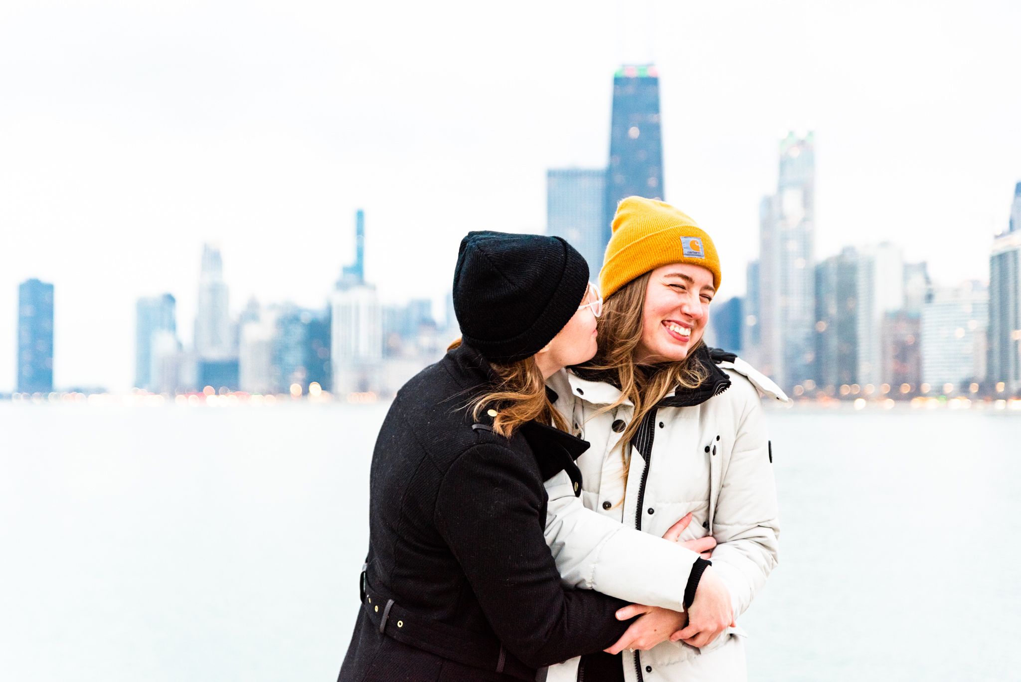 two women on pier at North Avenue Beach hugging and laughing