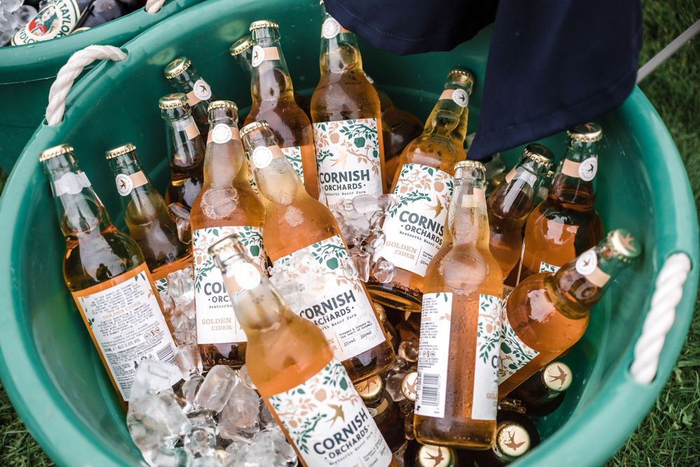 Ice bucket filled with bottles of Corona beer chilling at outdoor event.