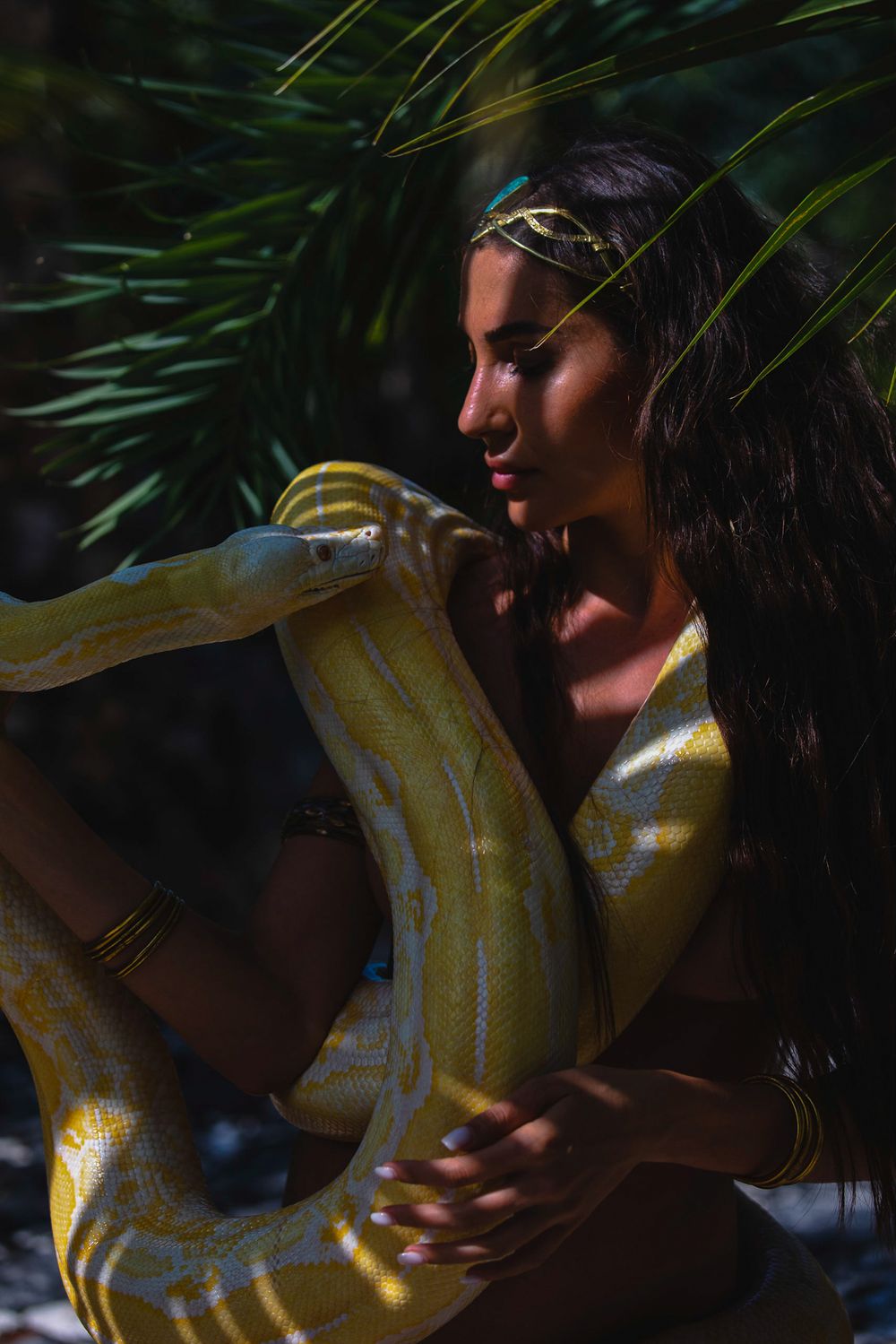 goddess isis staring at and holding a massive python