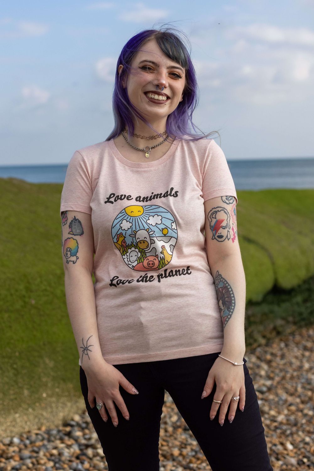 Alternative tattooed white model wearing small vegan fashion brand along Hove beach seafront in East Sussex.