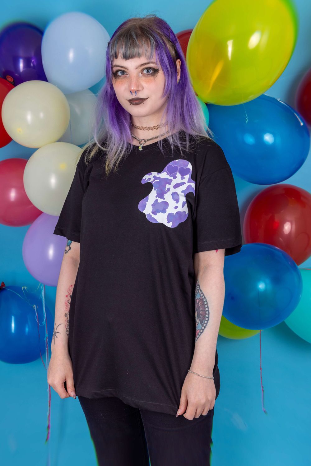 Alternative purple haired white model posing in front of a balloon background for small fashion business Grunge Monkey.
