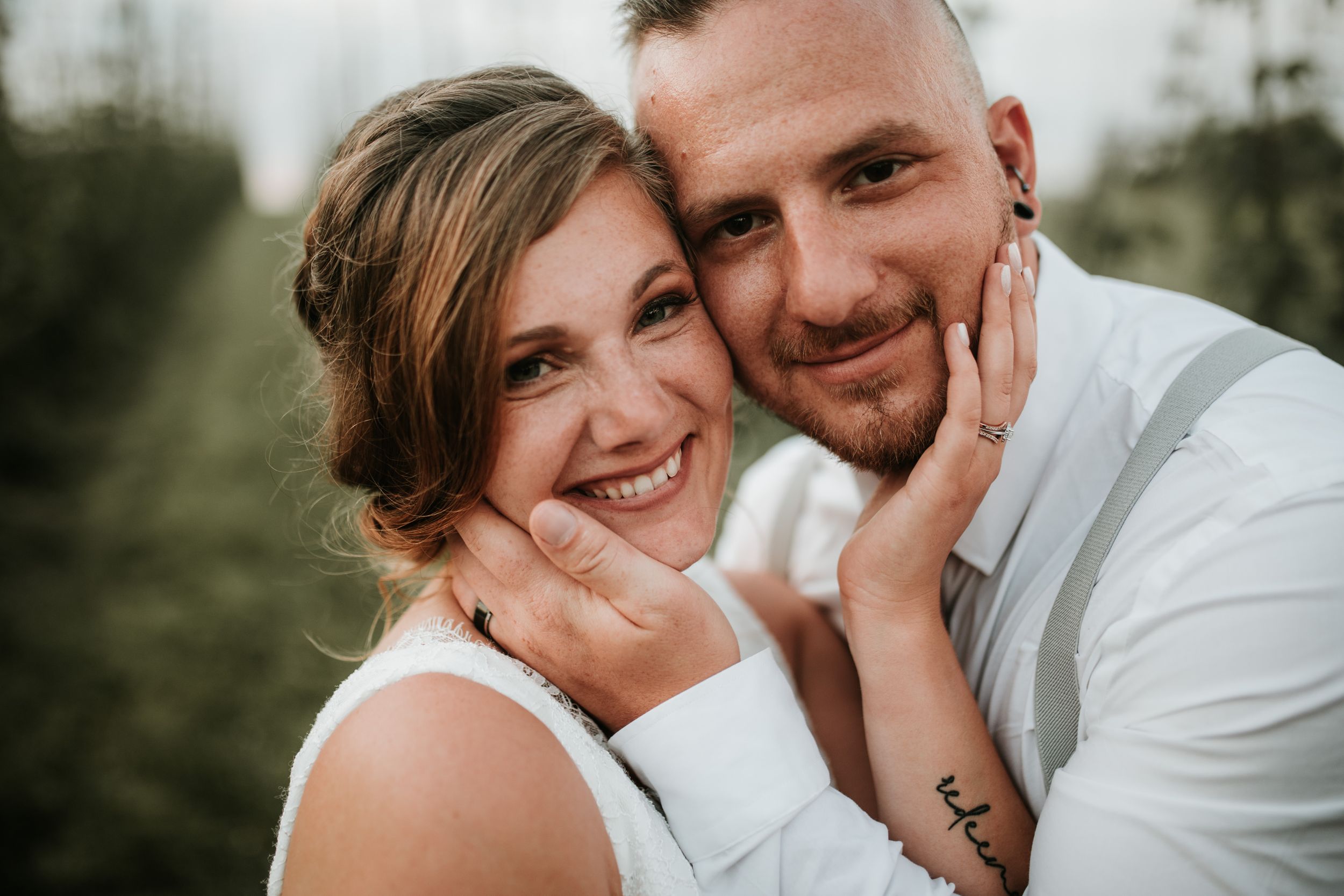 close up of bride and groom smiling at the camera