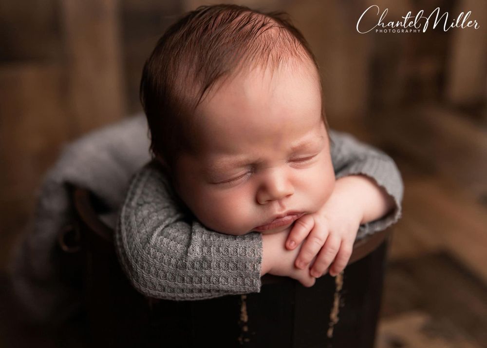 newborn baby boy chin on hands in bucket