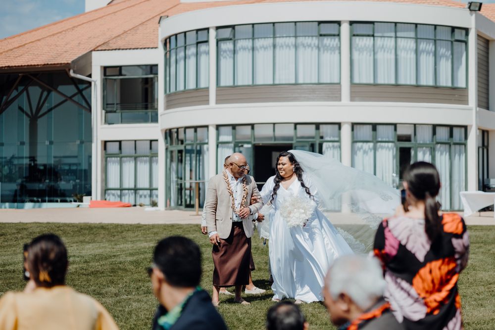 Wedding festivities taking place on a lawn in front of a contemporary building.