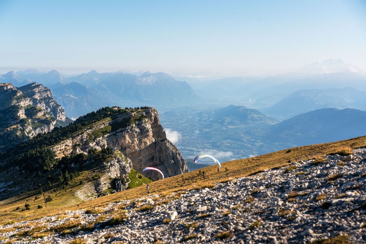 Rocky mountain landscape with dramatic cliffs overlooking misty valley below.