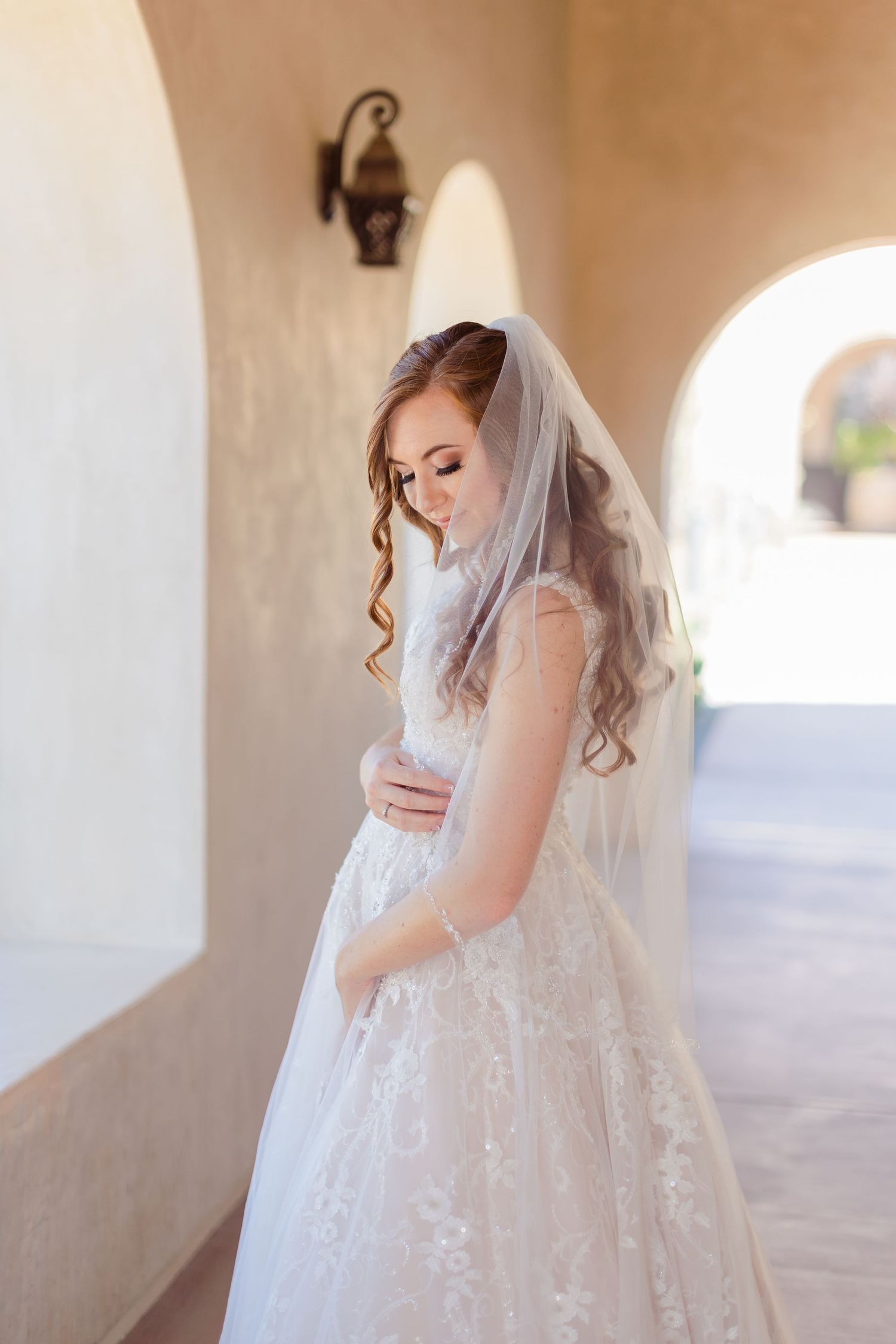 Bride looking down with veil and bridal makeup