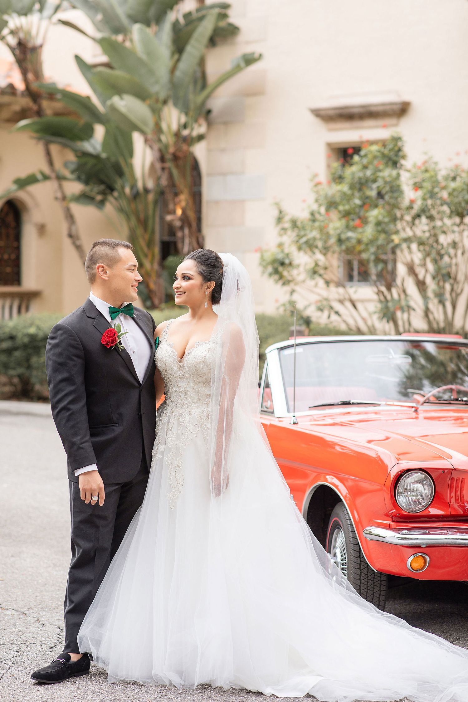 Groom and bride with a red car on a background at the Powel Crosley Estate