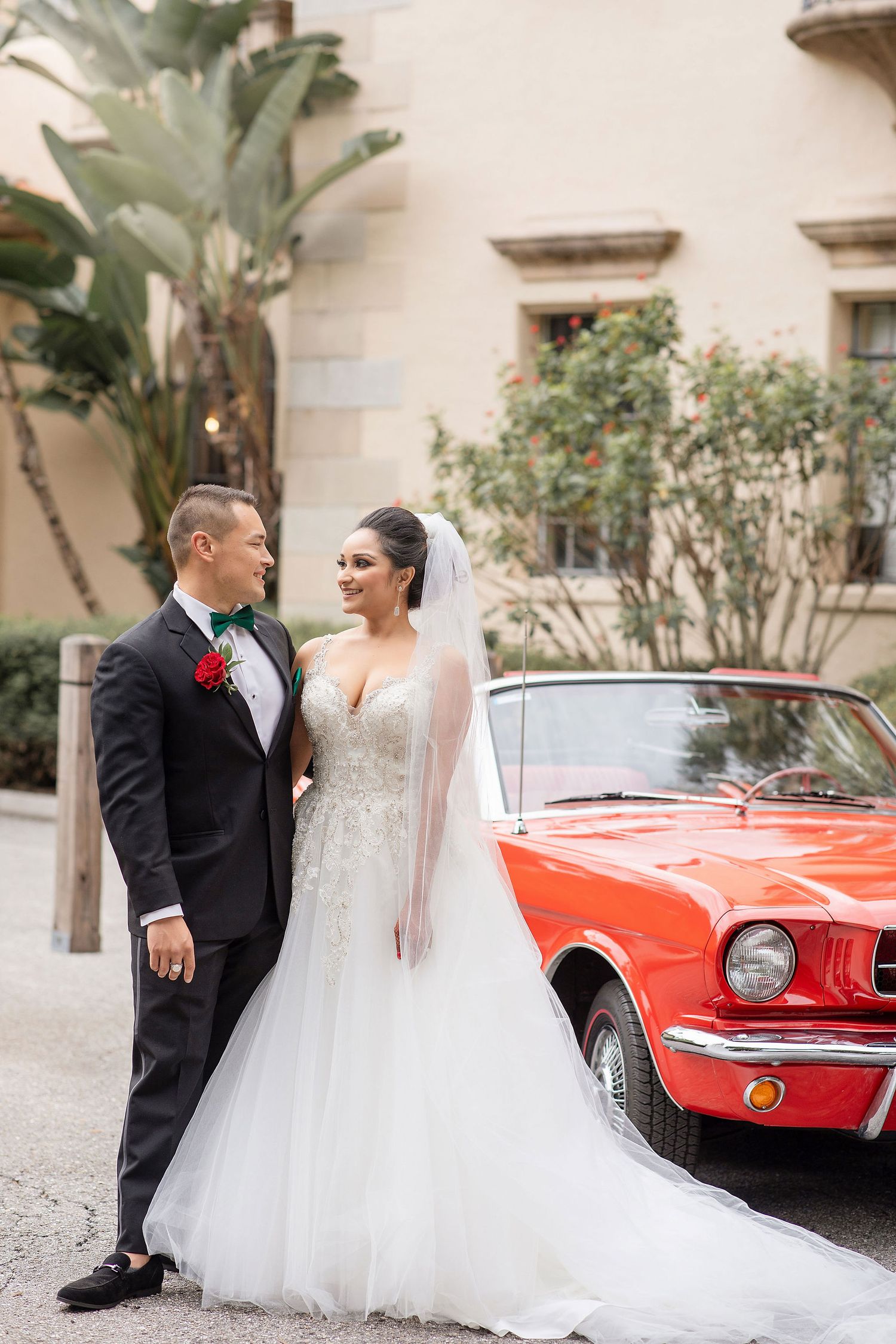 Groom and bride with a red car on a background at the Powel Crosley Estate