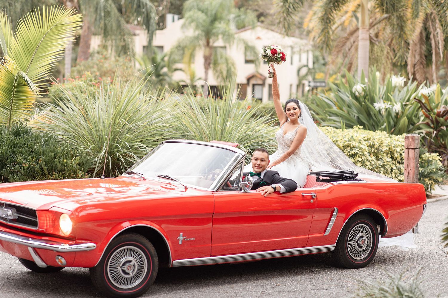 bride and groom with a red car on a background at the Powel Crosley Estate