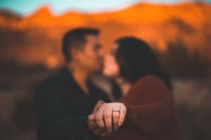 Future bride showing off her ring while kissing fiance