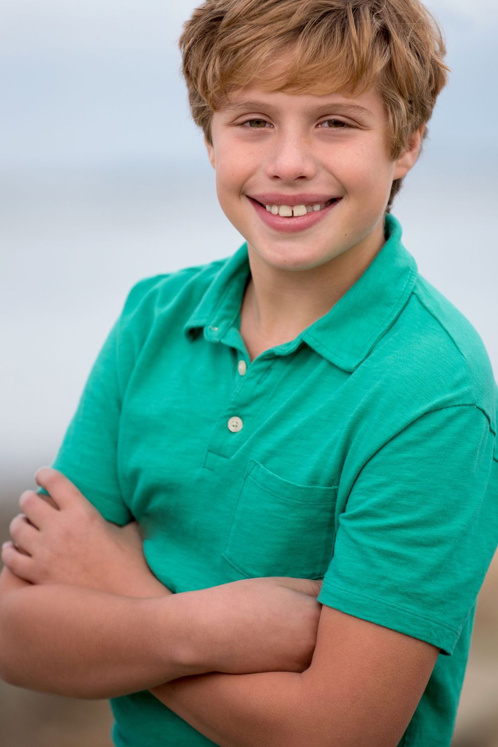 Tween male model wearing polo shirt with arms crossed