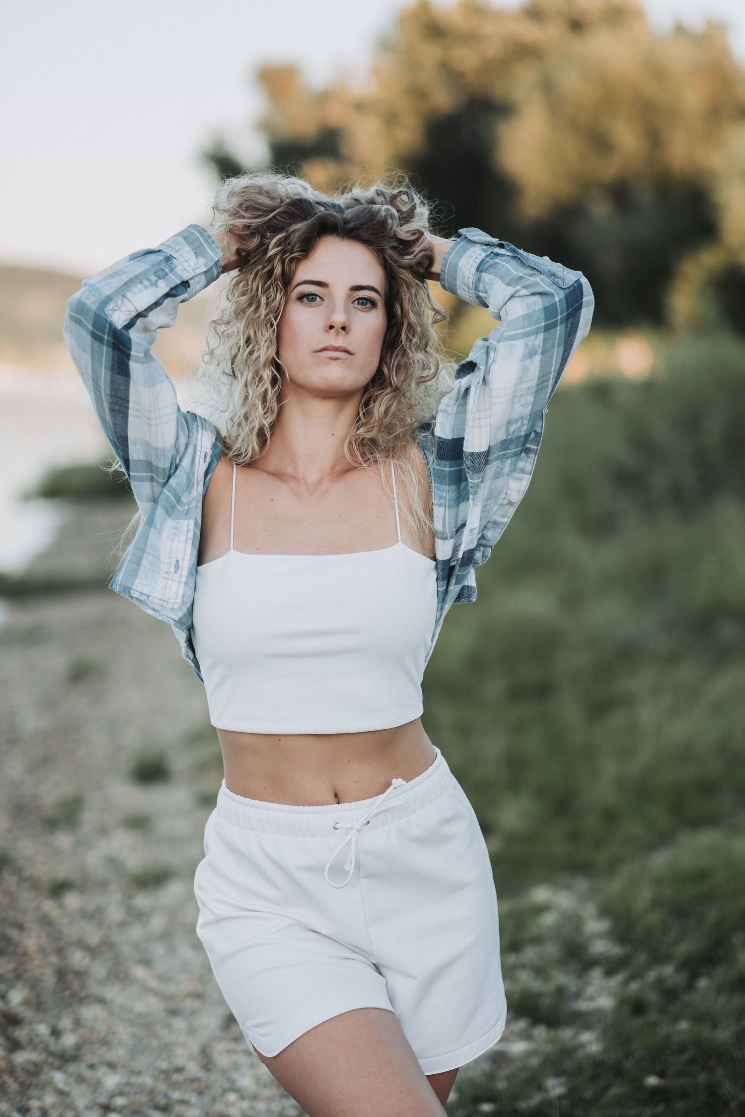 Summer fashion shot with plaid jacket and white coord set against natural backdrop.