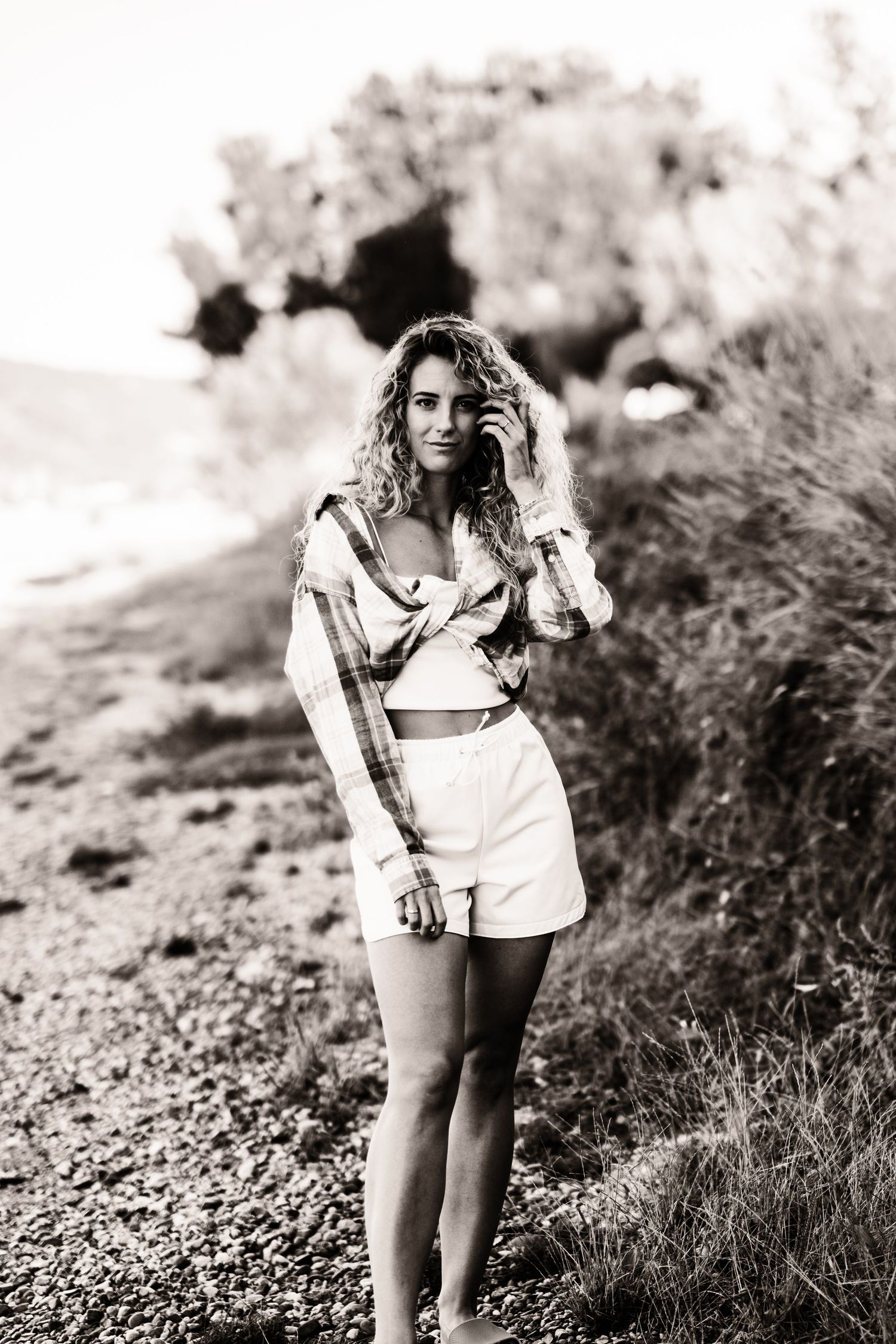 Black and white portrait of beachwear fashion on rocky coastal path.