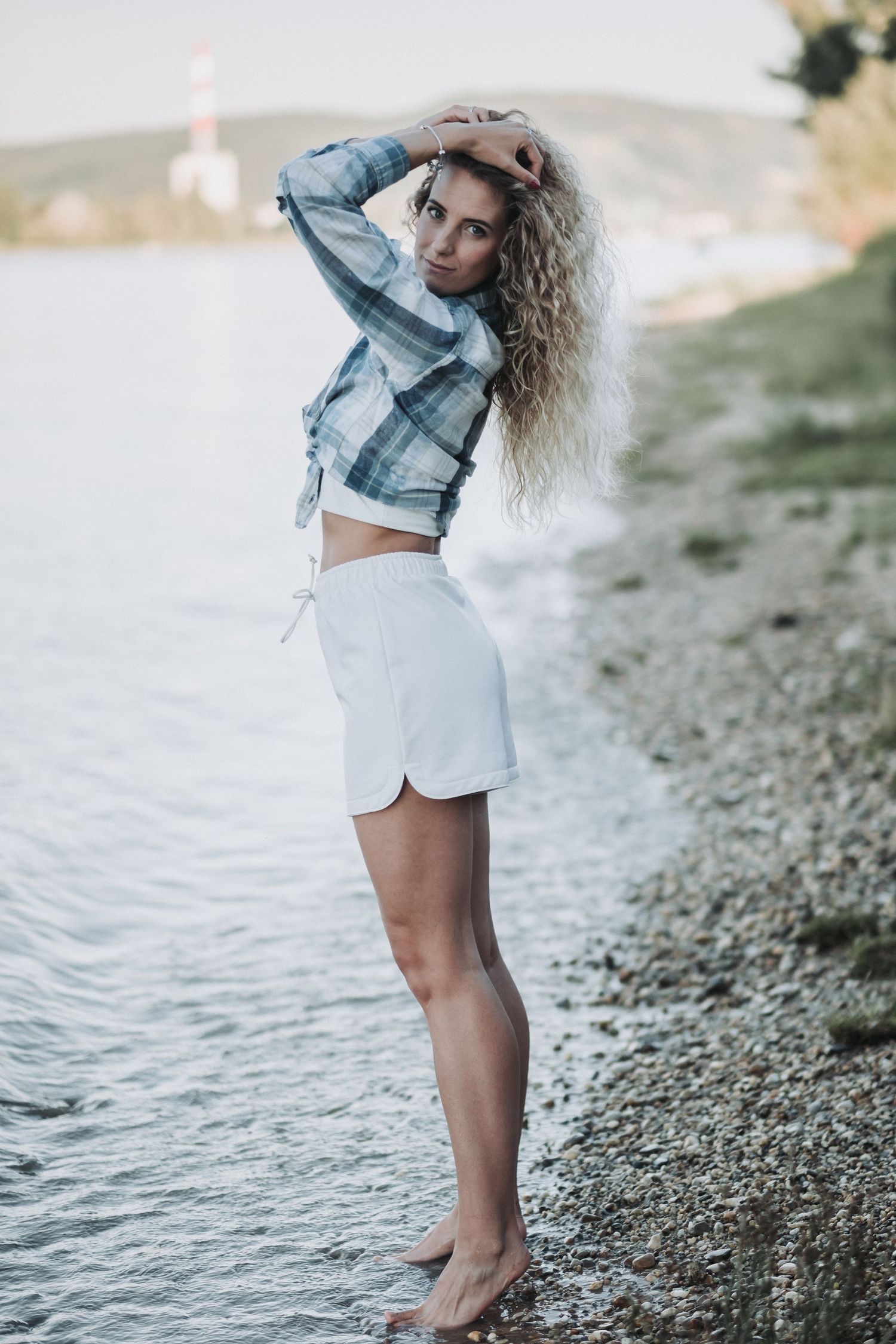 Summer fashion shoot featuring plaid crop top and white shorts by the water.