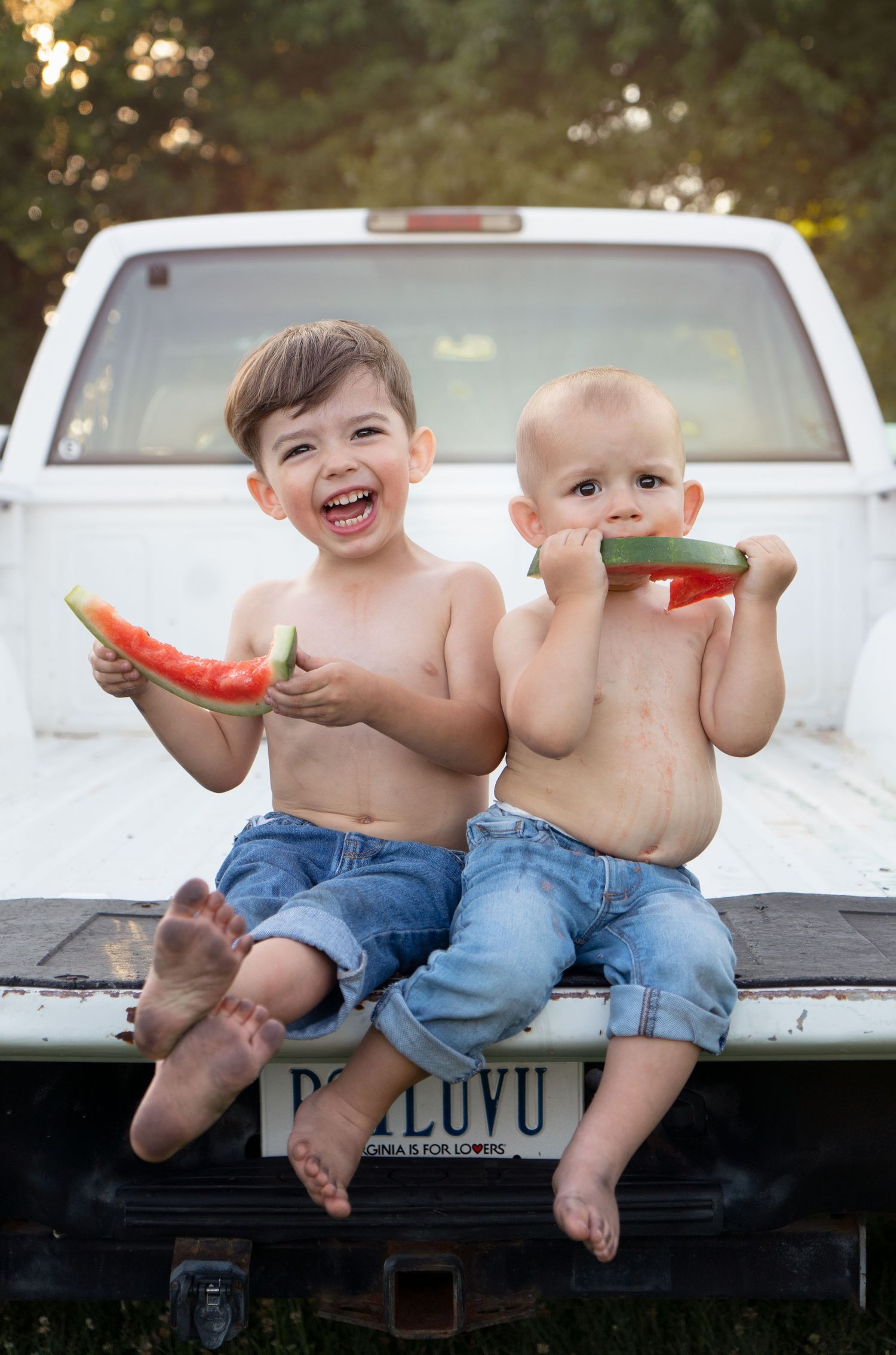 brothers sit on tailgate eating watermelon