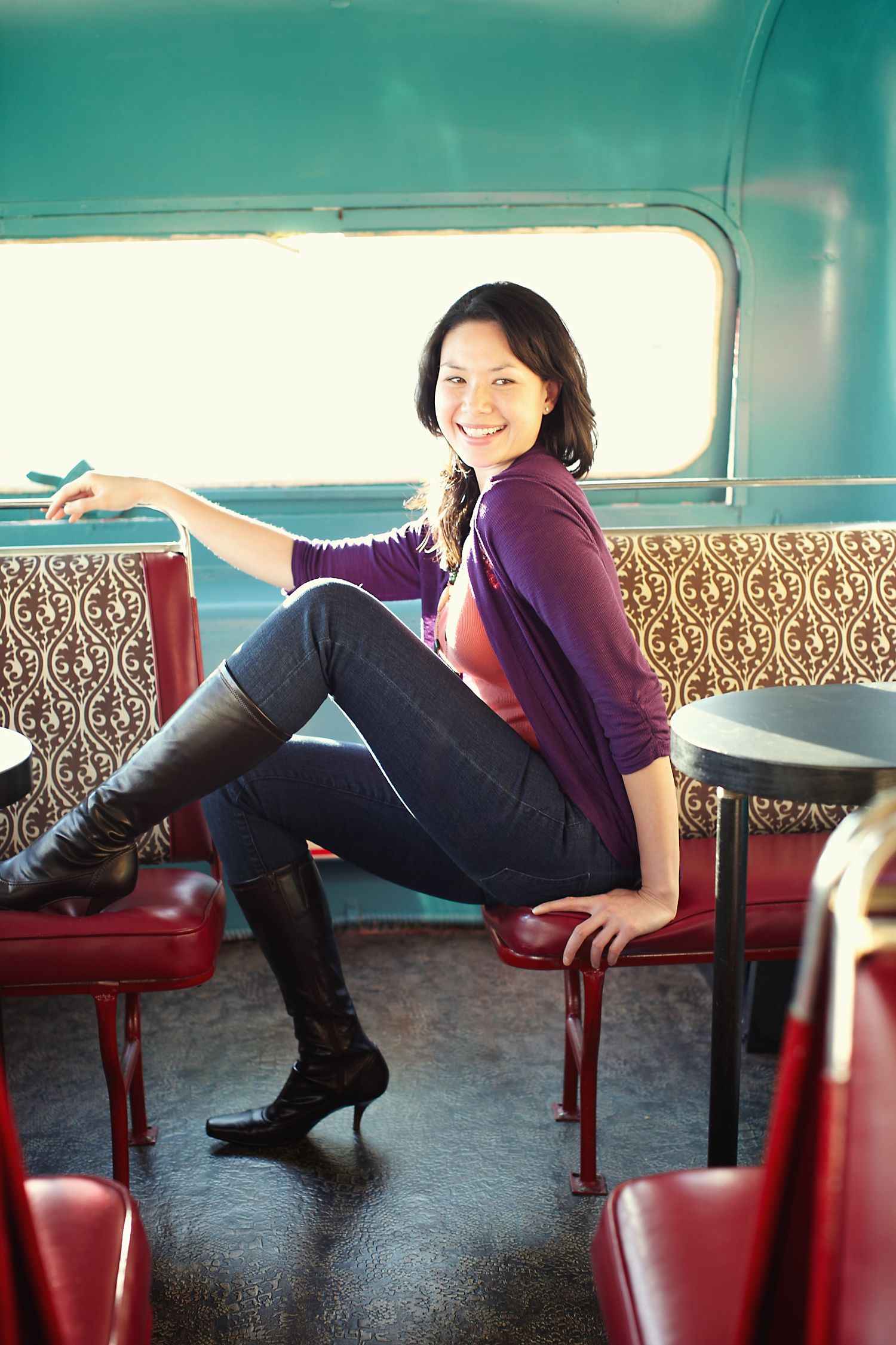 Casual portrait taken inside vintage bus with red leather seats.