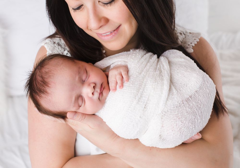 Newborn held by mother taken by newborn photographer in Penticton