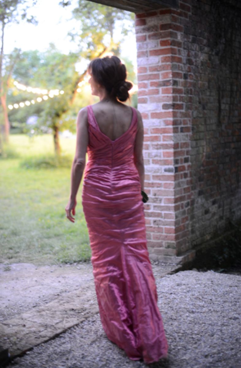 elegant woman wearing evening gown walking through a garden at grange park opera surrey event