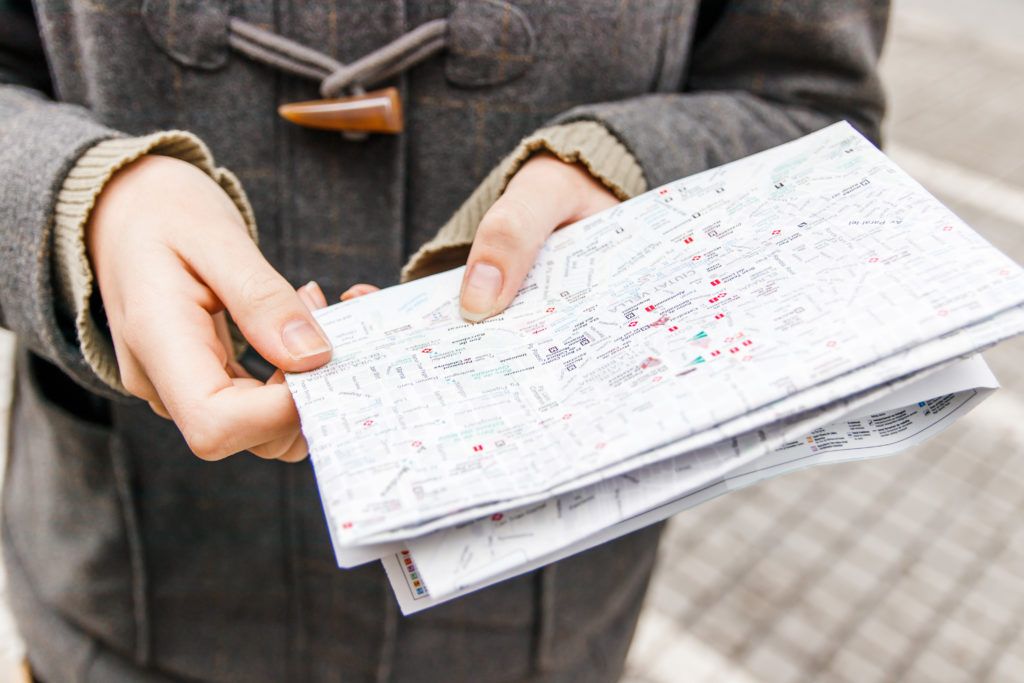 Close up of hands holding a folded map of Verona, Italy