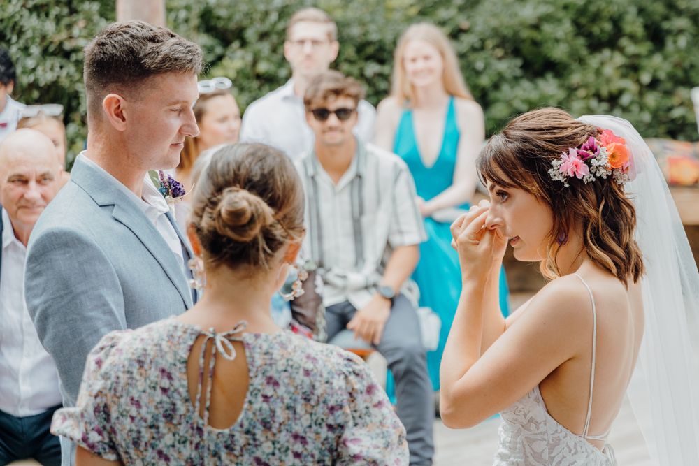 Intimate outdoor wedding moment with light blue and floral accents.