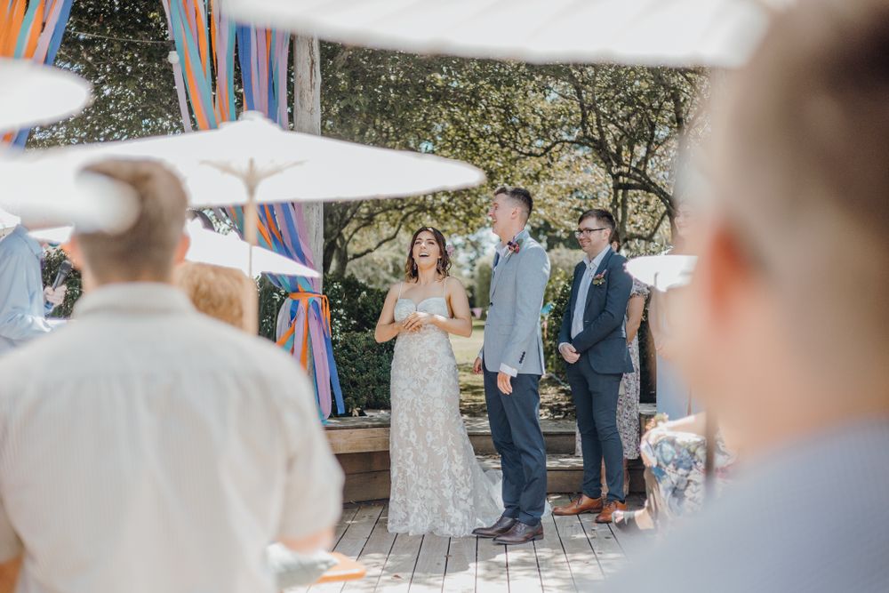 Wedding ceremony under decorative streamers with natural garden backdrop.