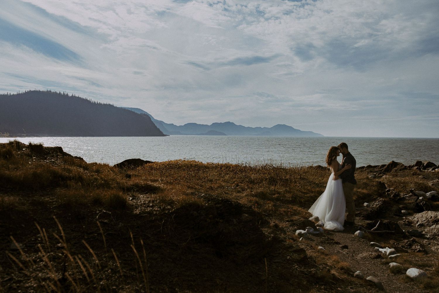 la mariée et le marié collés durant leur séance de photo la journée de leur elopement en gaspesie, au quebec, canada