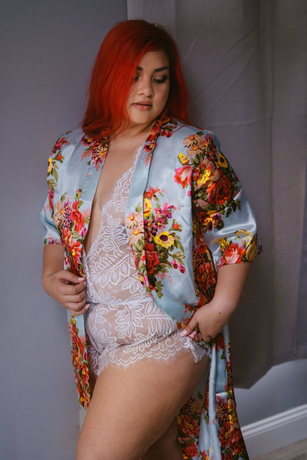 woman in white lingerie and silk bathrobe doing a sexy pose looking down her shoulder