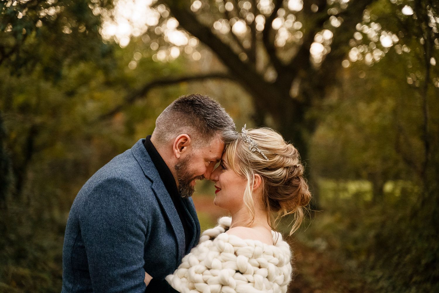 A newly wed couple embrace during golden hour at their winter wedding.