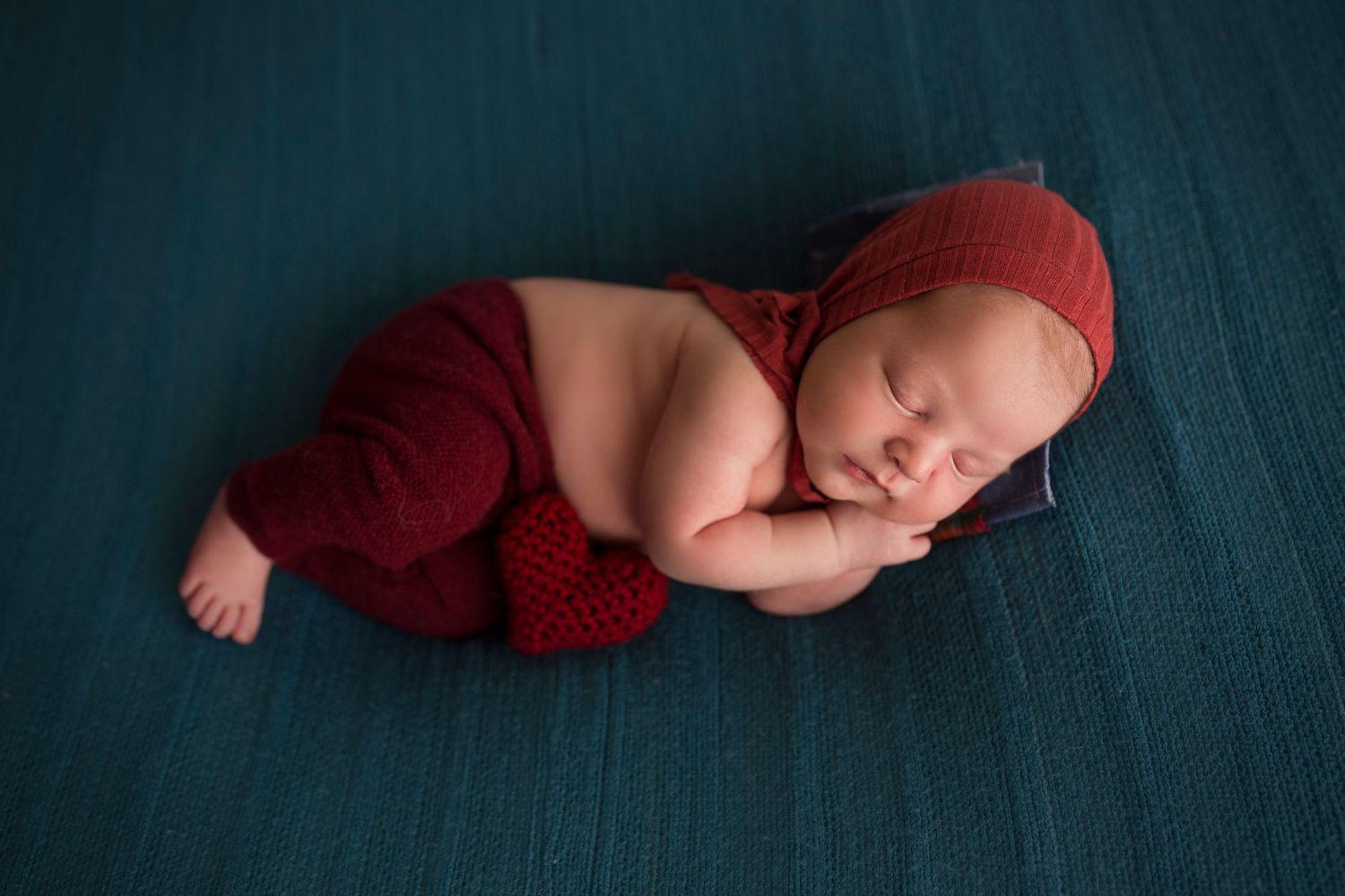 baby boy dressed in red on a blue backdrop