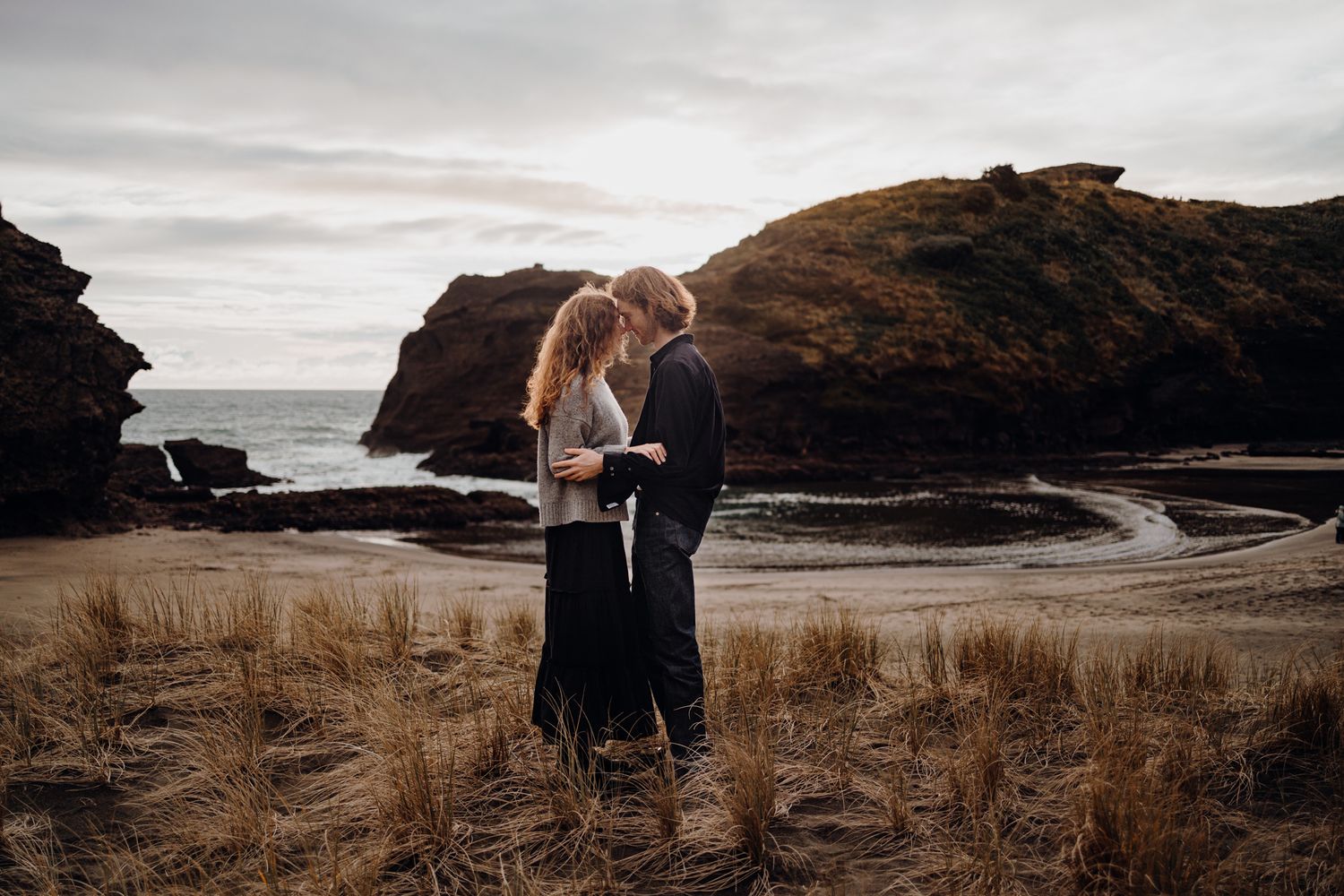 Couple head cuddling in Piha for their engagement shoot with Apertured Media-Auckland Wedding Photographer