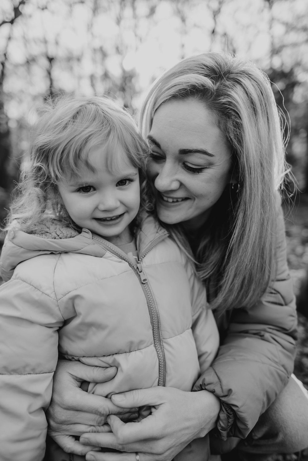 A touching moment captured in black and white of parent and child embracing outdoors.