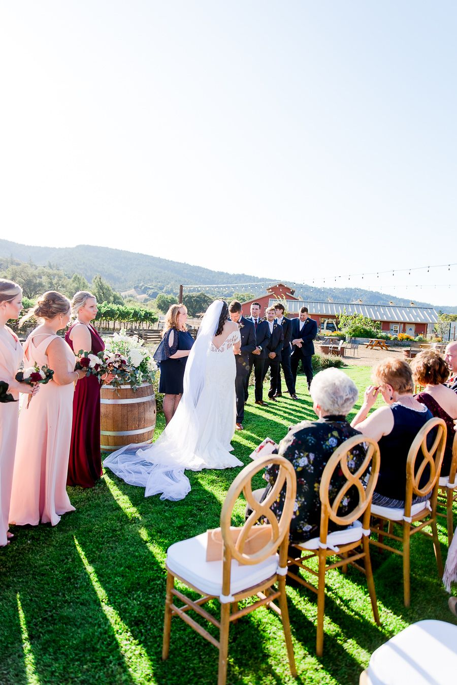 bride and groom face each other in front of wedding guests at outdoor fall wedding on Pennyroyal Farm in North Cali