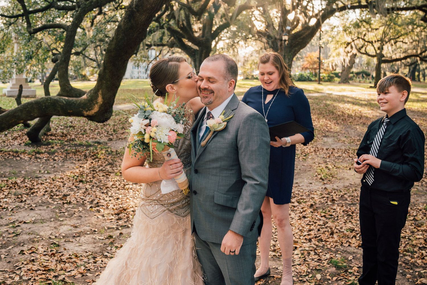 Bride kisses groom at wedding ceremony in New Orleans City Park