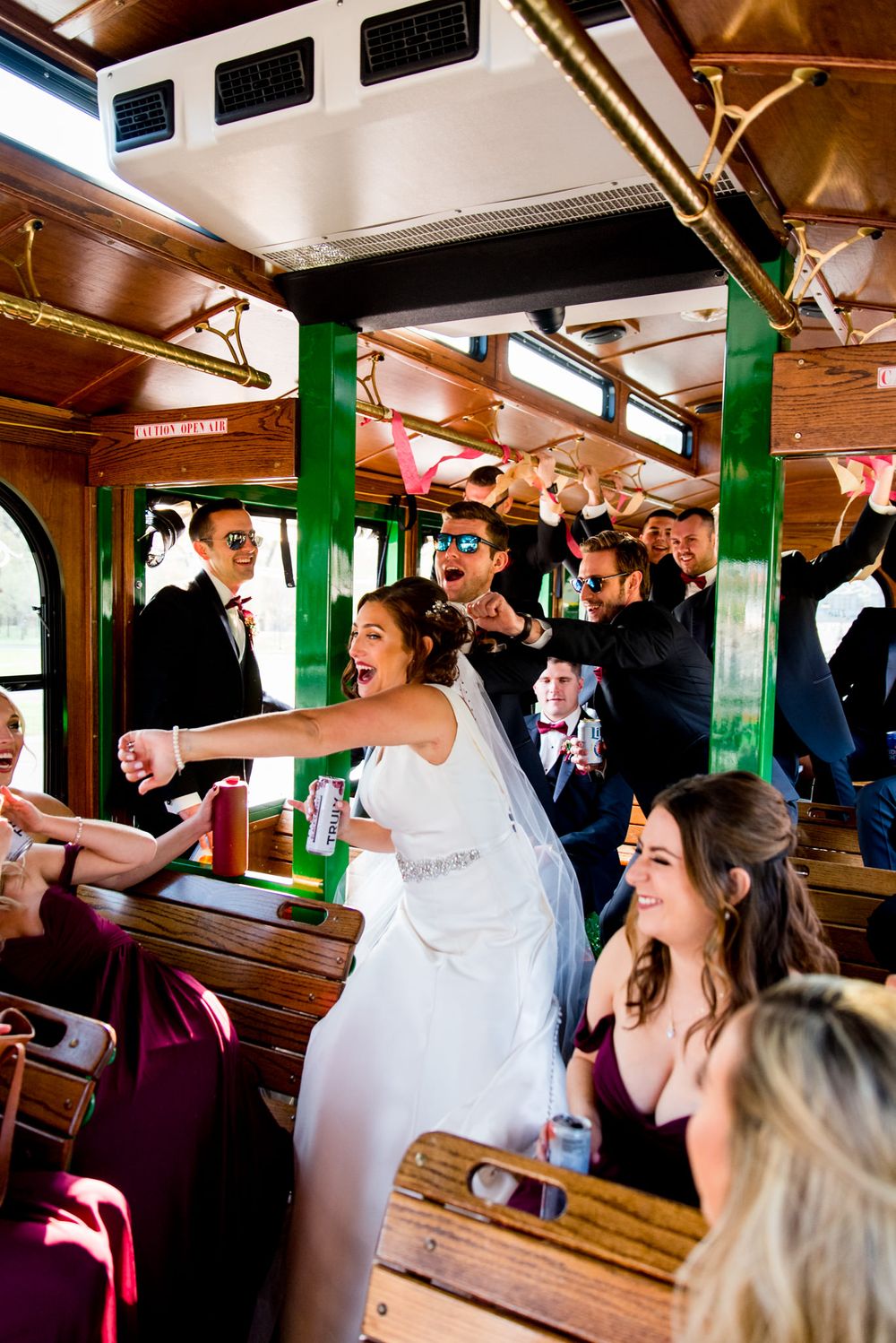 laughing wedding party dances on trolley after fall chicago wedding