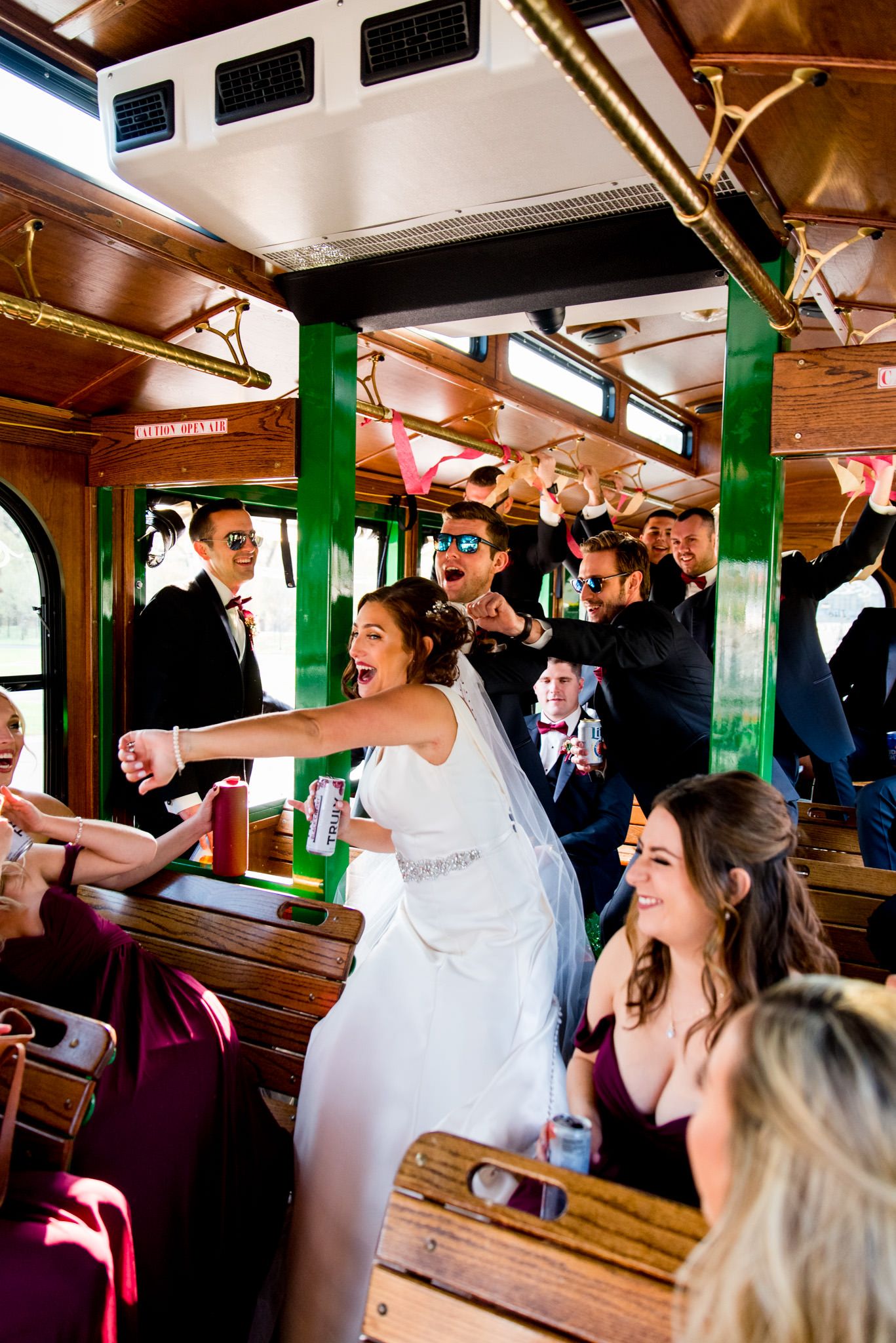 laughing wedding party dances on trolley after fall chicago wedding