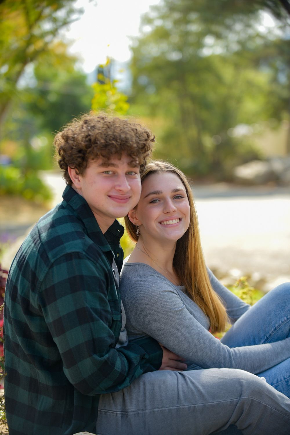 Young couple sitting together outdoors in casual wear.