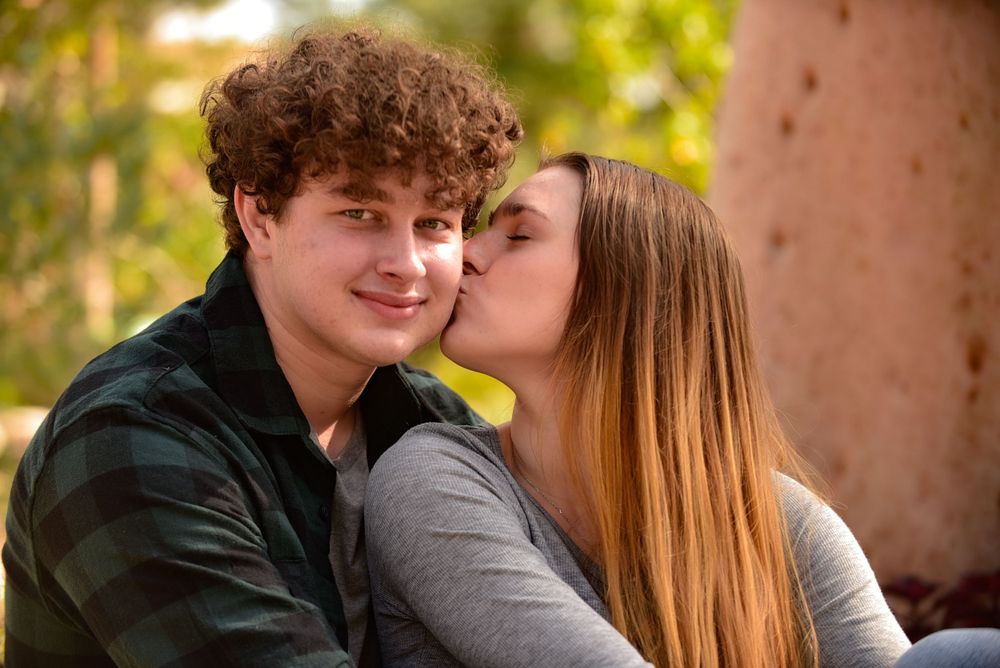 Young couple sharing an intimate moment outdoors in autumn setting.
