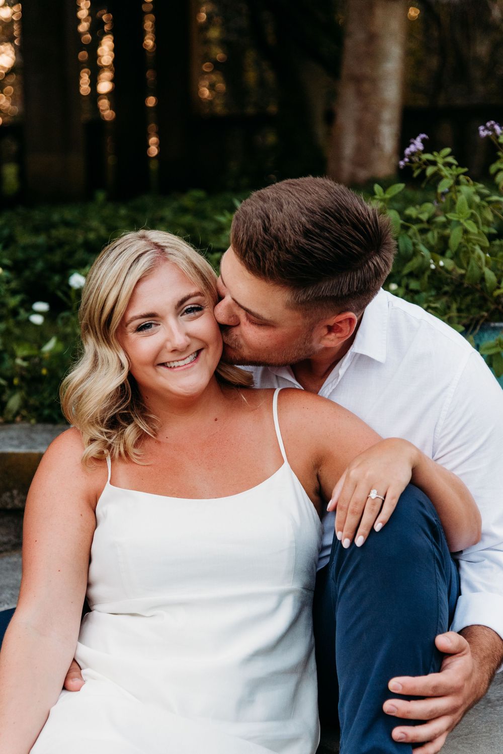 Intimate outdoor portrait of couple sharing a tender moment in golden sunlight.