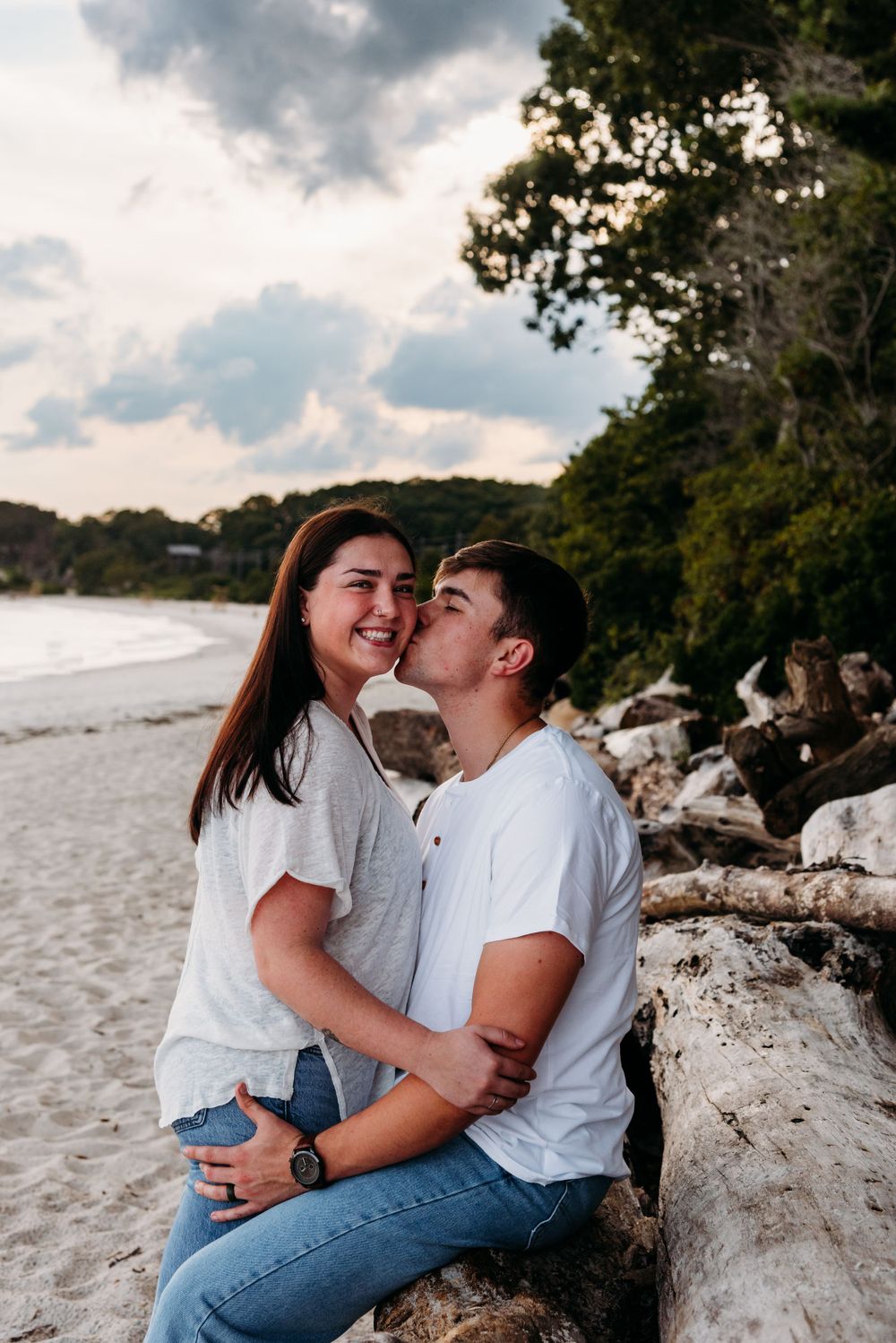 Casual beach portrait of couple sharing intimate moment on sandy shore.