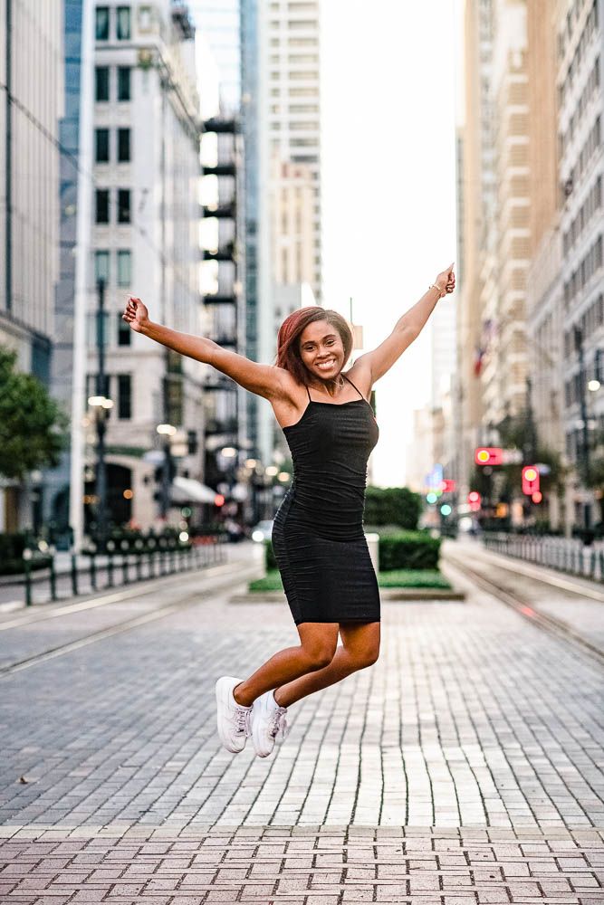 High School Senior Girl Jumping in Main Street