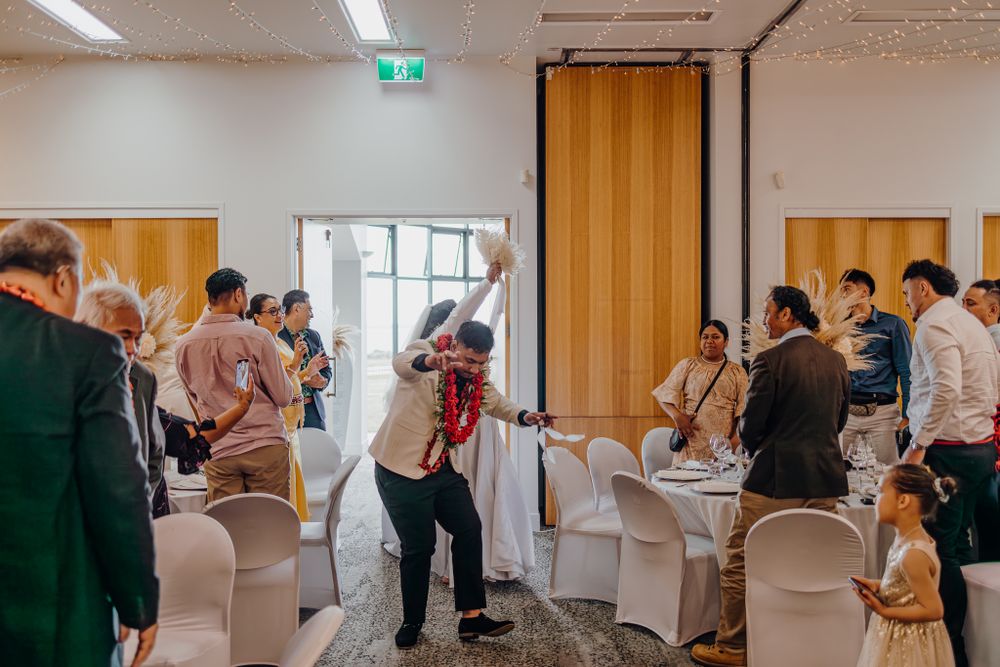Wedding reception venue with guests mingling in a modern room with wooden sliding doors.