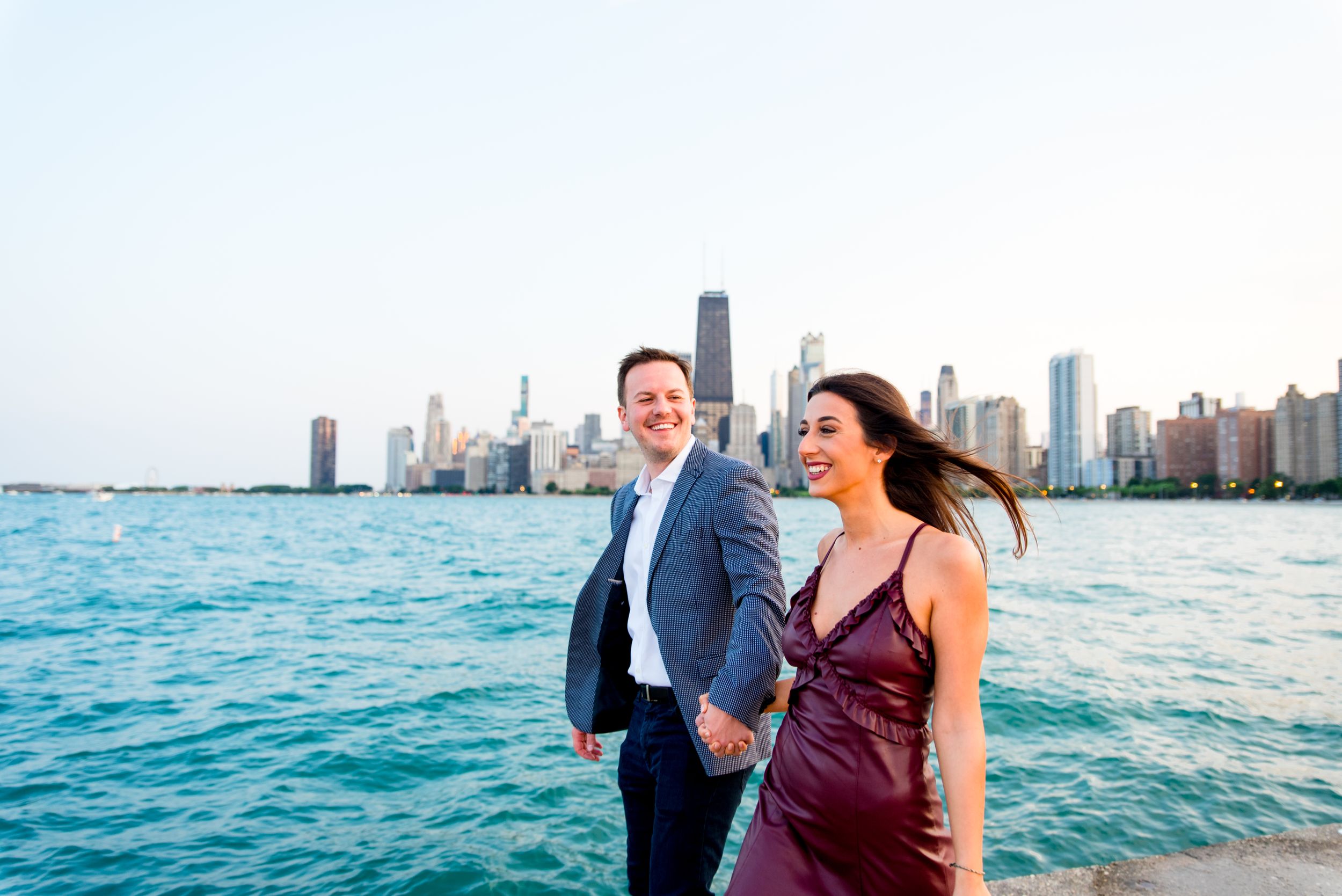 man and woman holding hands walking along pier at North Avenue Beach Chicago