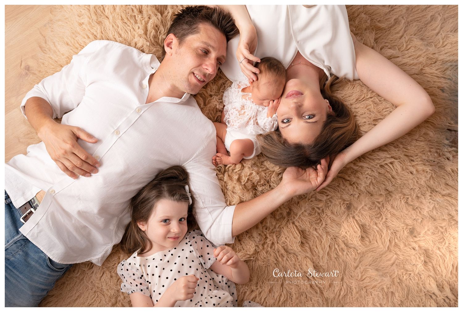 Newborn family photo dressed in white laying on a rug in Gumpoldskirchen, Mödling, Austria